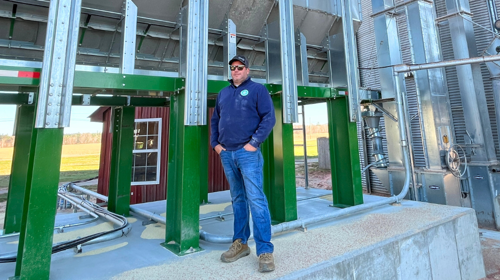Jim Pitreau stands at the base of Green Thumb Farms' new grain dryer.