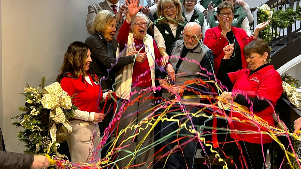 People on staircase cutting a ribbon.