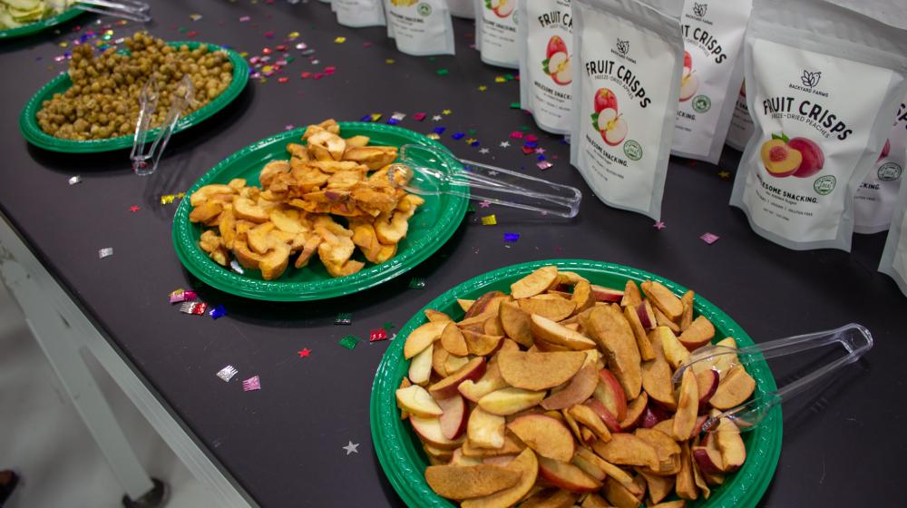 Freeze-dried fruit chips in plates on a table laid out for sampling. 