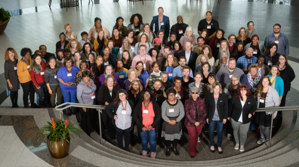 Cooperative developers and members of home care cooperatives gather at the National Home Care Cooperative Conference. Group of smiling people standing in a large open room.