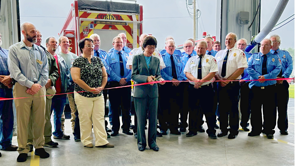 Senator Susan Collins stands with members of the Corinna Fire Department and others at the ribbon cutting ceremony for the new fire station.