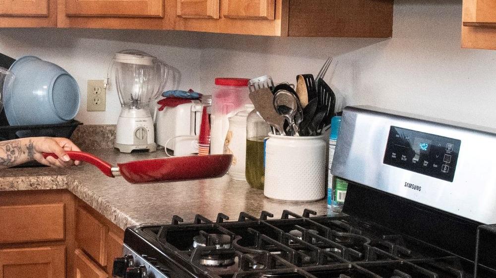 A kitchen with counters, cupboards and a stove