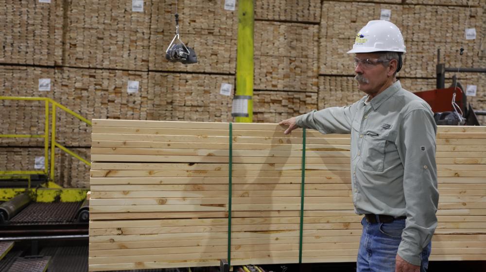 Man standing next to lumber