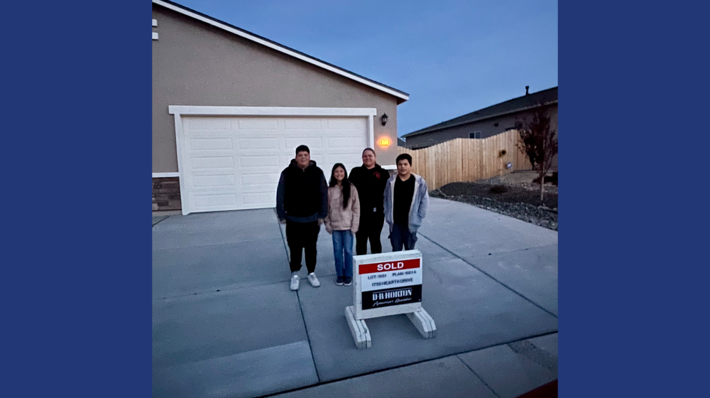 A family stands outside their home.