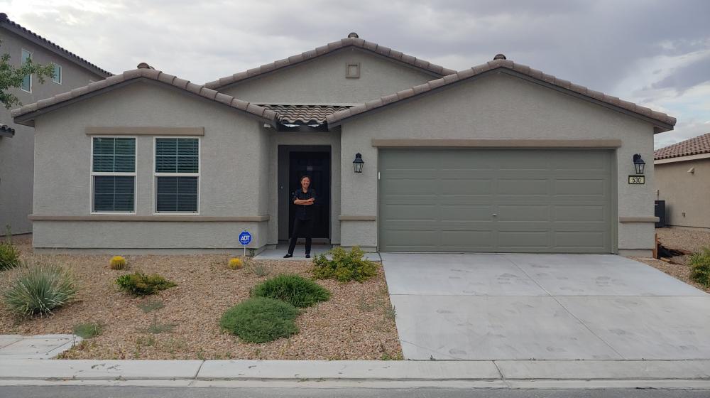 A woman stands outside her home in Nevada.
