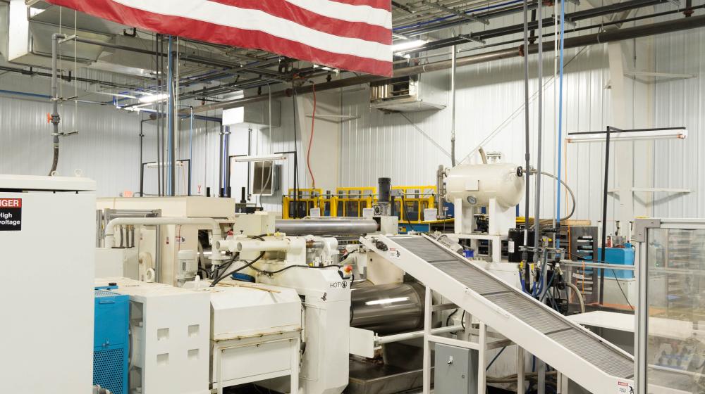American flag above Life Floor manufacturing equipment