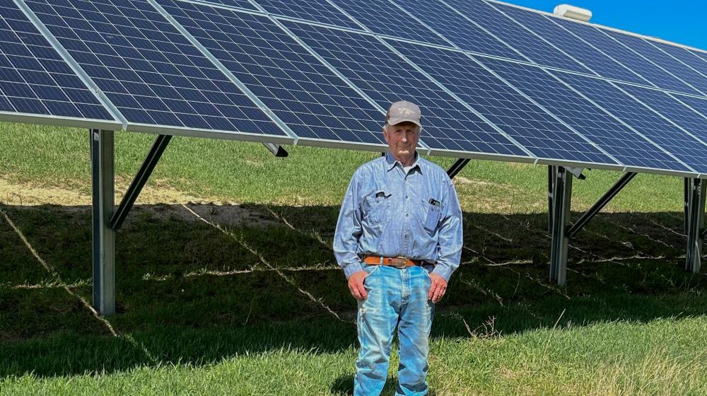Richard Smith stands next to his solar array on his farm in Morris, Minnesota.
