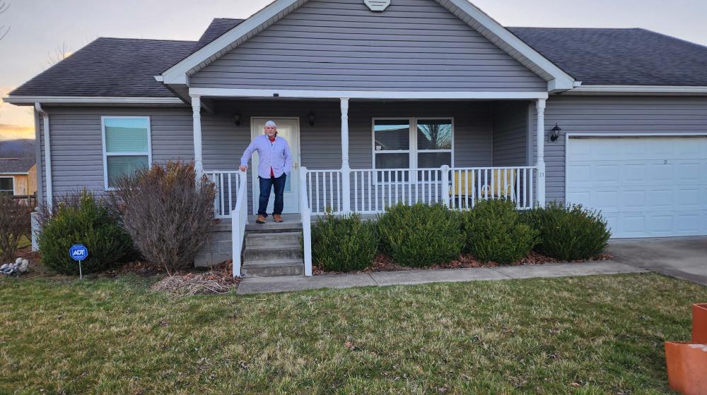 Richard Smith stands on the porch of his new home in Elkins, West Virginia.
