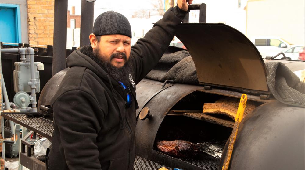 Ruben Lopez Opening Smoker to show meat cooking inside.