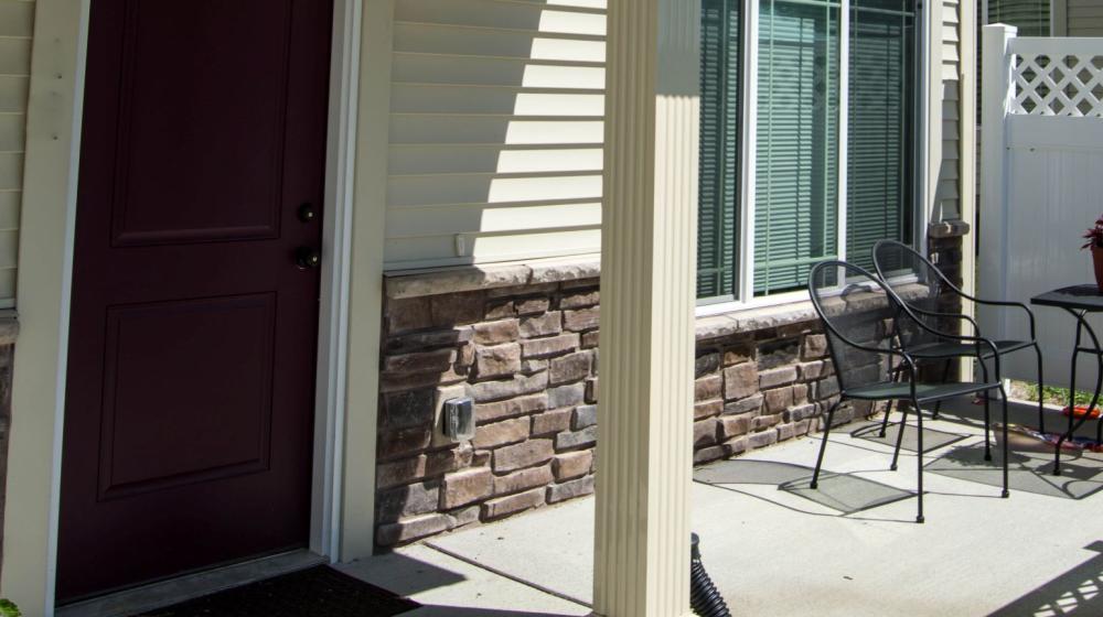 door to a home, sidewalk, patio, pillar