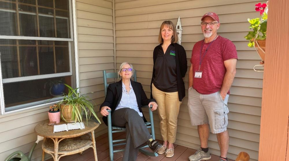 Lisa Gallant, seated, on the front porch of her home in South Paris, Maine, with Rural Development State Office Specialist Wendy Palmer and Community Concepts Inc. Self-Help Manager Michael Sampson.