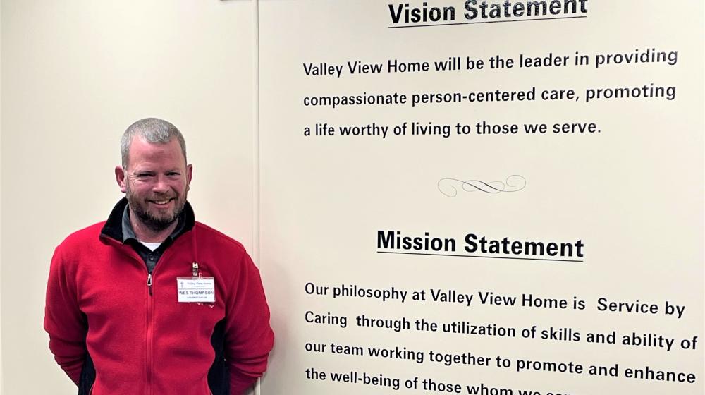 A man standing beside Vision Statement and Mission Statement text