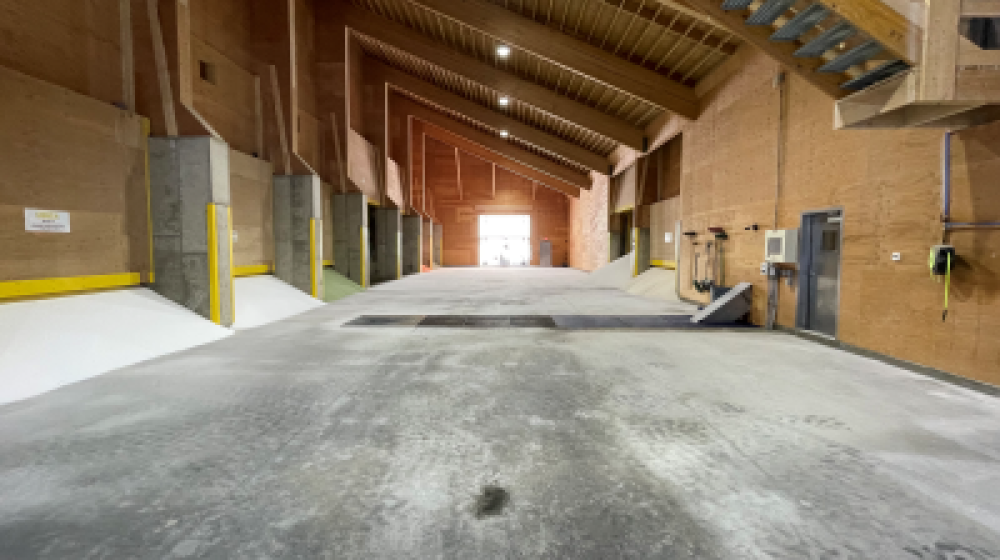 Large, cavernous warehouse with bins of fertilizer.