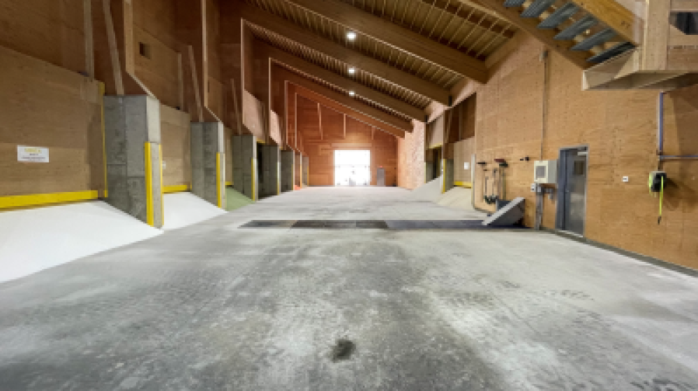 Large, cavernous warehouse with bins of fertilizer. 