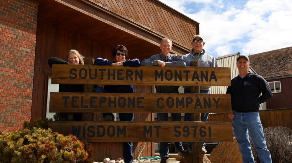People standing behind a sign