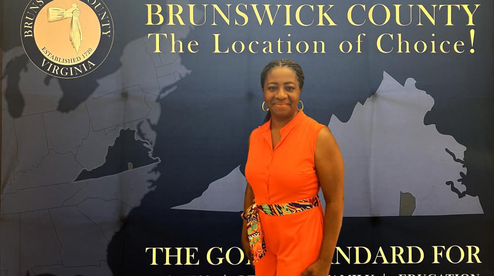 Alfreda Jarrett-Reynolds poses in front of a Brunswick banner