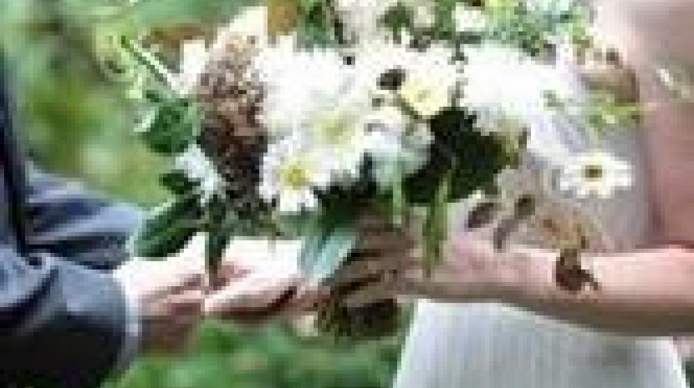 A bride holds a floral arrangement made by 3 Porch Farm, an fusion of artistic expression and natural rhythms