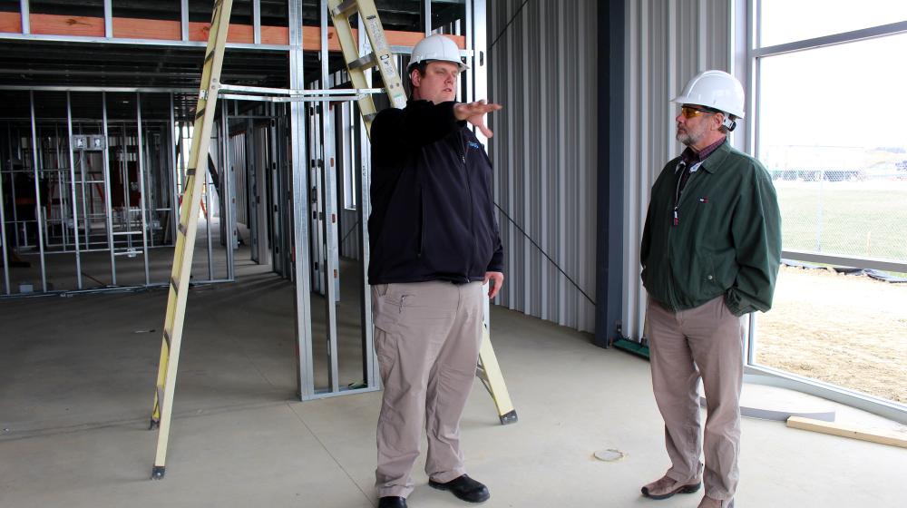 Fixed Base Operations Manager Chris Botkin (left) gives Area 2 Specialist Robert Wilson a tour of the new hangar while it is under construction.