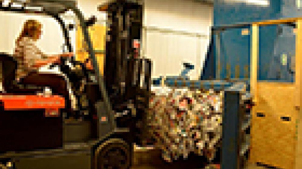 Forklift moving a bale of recycling