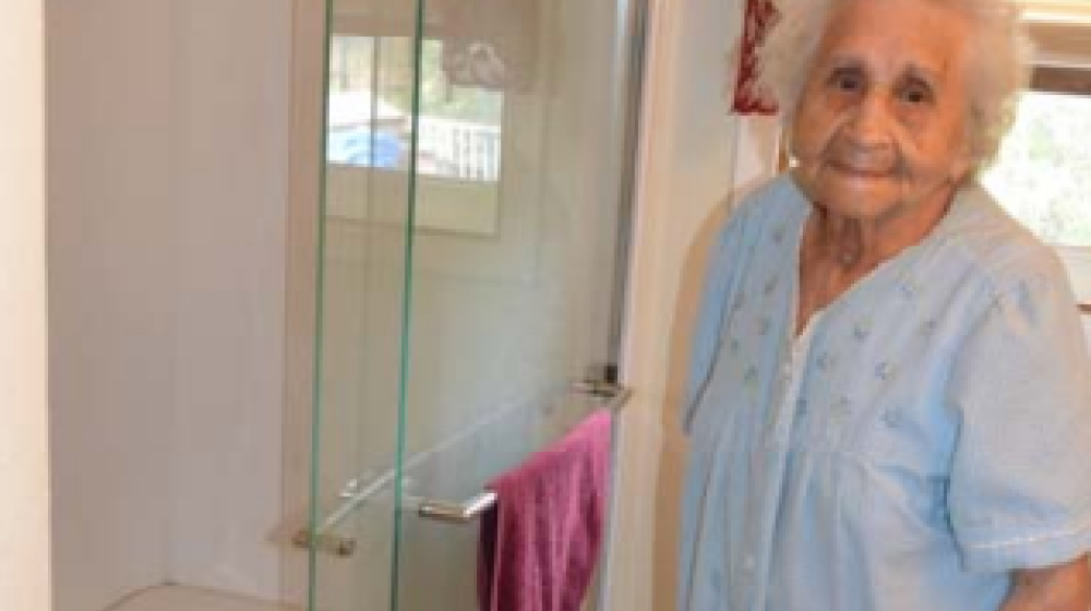 woman standing beside new shower in bathroom