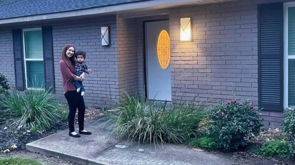New homeowner Kaitlyn and son with new home funded by Rural Development Single Family Housing loan.