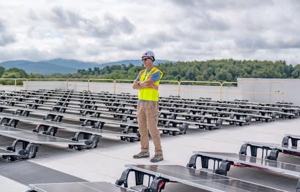 Owner Brett Hayes surveys newly installed solar panels on the roof of the Zeus Digital Theater.