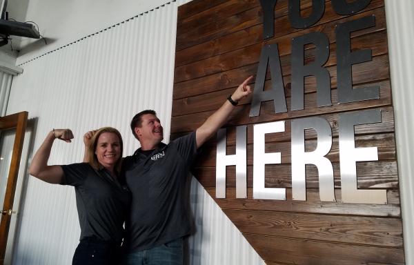 Couple pointing to Nevada shape sign at The Grid Restaurant in Fallon Nevada