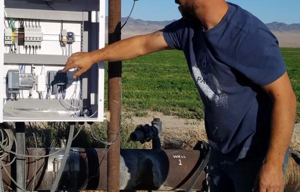 Operator managing controls on solar powered irrigation in Railroad Valley, Nevada.