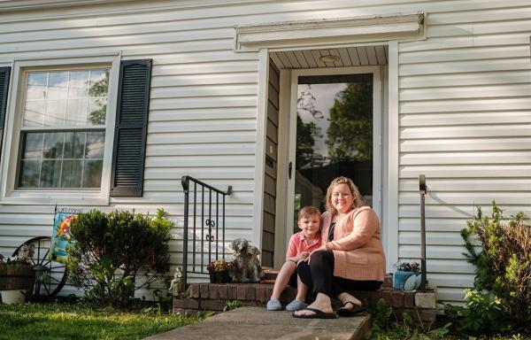 Alicia and her son, Sy, outside their new home