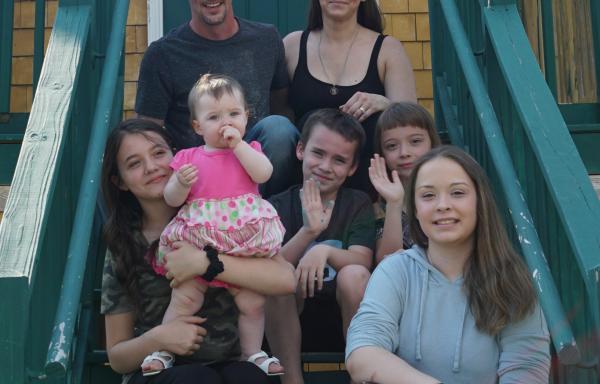 The LaRue Family sits on the steps of their new home