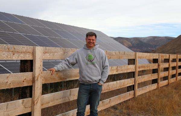 Brandon Willis, Rancher's Insurance owner standing in front of ground mounted solar panels in Laketown, Utah.