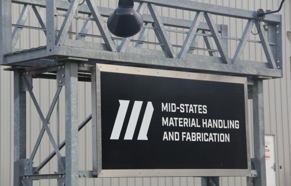 A sign in front of an industrial building states Mid-States Material Handling and Fabrication