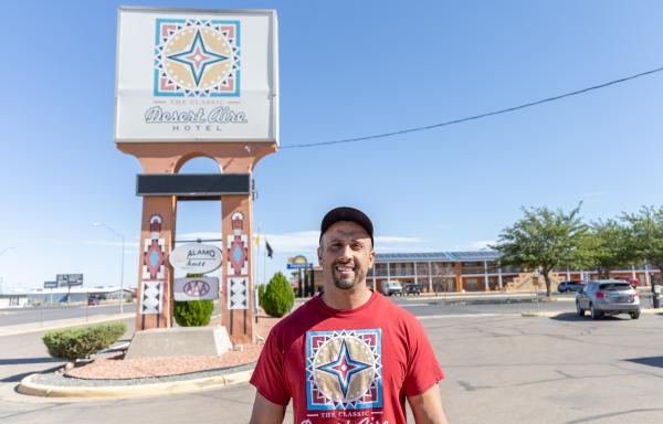 Man standing in front of Desert Aire Hotel sign
