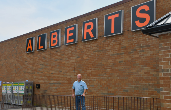 Man standing in front of grocery store. 
