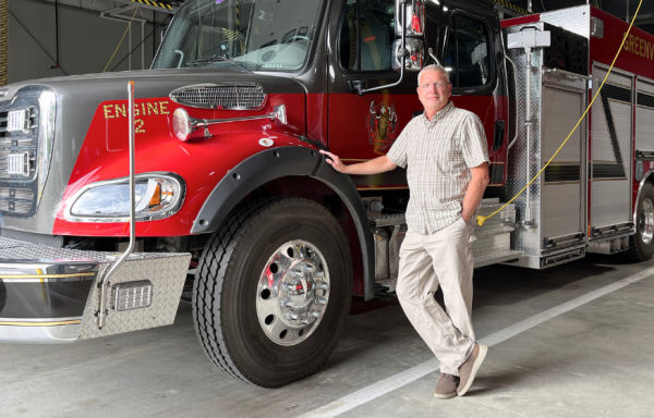 Greenville Town Manager Mike Roy stands in front of one of the town's fire trucks in the new public safety building.