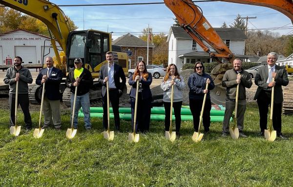 People with shovels in front of large machinery