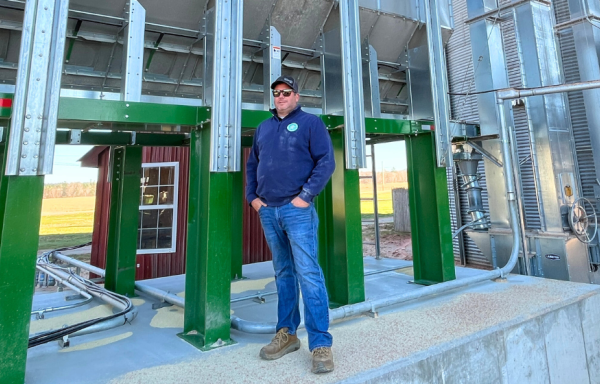 Jim Pitreau stands at the base of Green Thumb Farms' new grain dryer.