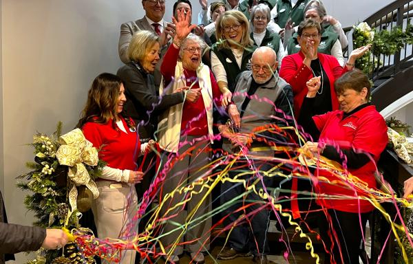 People on staircase cutting a ribbon.