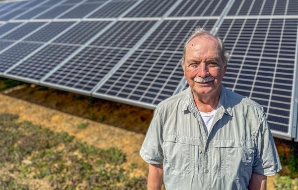 Bob Threewitts standing in front of his ground-mounted solar panels