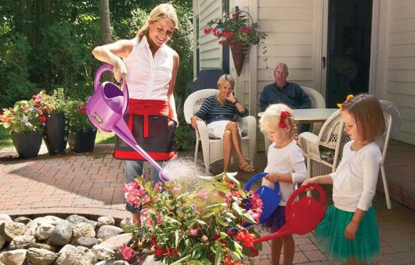 Dramm Executive Vice President and Corporate Relations Officer Heidi Dramm Becker waters plants with family