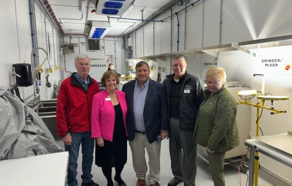 Officials gather for the grand opening of Central Lakes College's new mobile meat processing facility. 