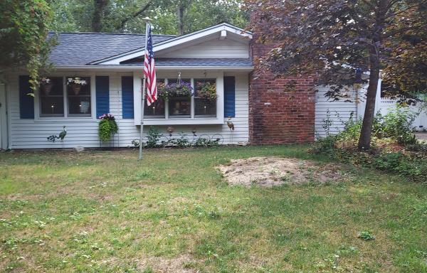A pretty white home with blue shutters and hanging plants
