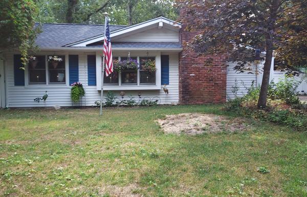 A pretty white home with blue shutters and hanging plants