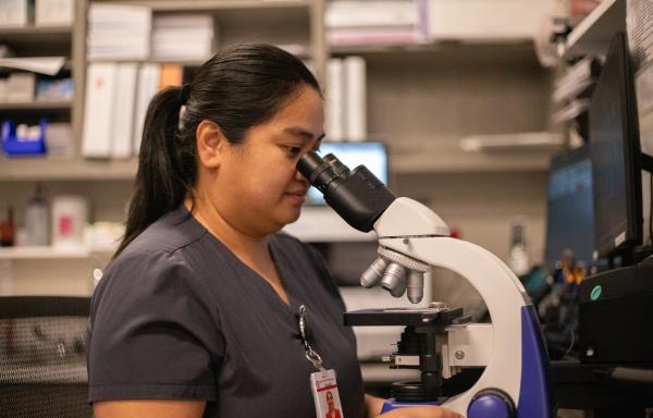 Lab Technician at Exceptional Hospital Bullhead City Looks Into Microscope.