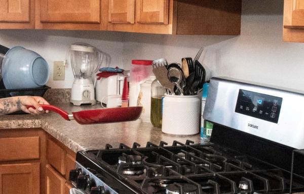 A kitchen with counters, cupboards and a stove