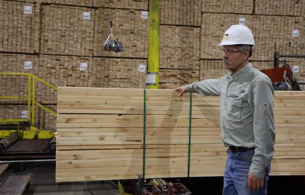 Man standing next to lumber