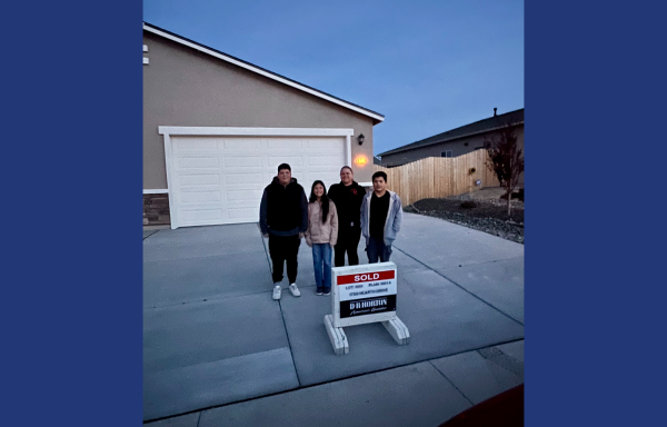 A family stands outside their home.