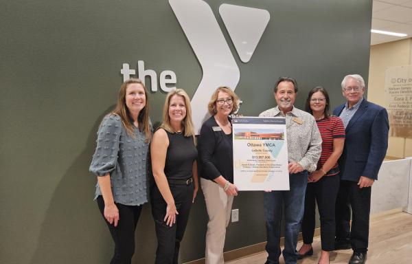 Picture of USDA Rural Development team presenting award poster to YMCA Leadership.