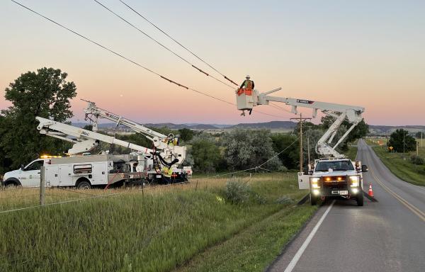 West River Electric Association crews use bucket trucks install power lines in South Dakota
