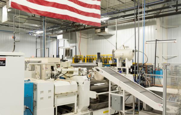 American flag above Life Floor manufacturing equipment